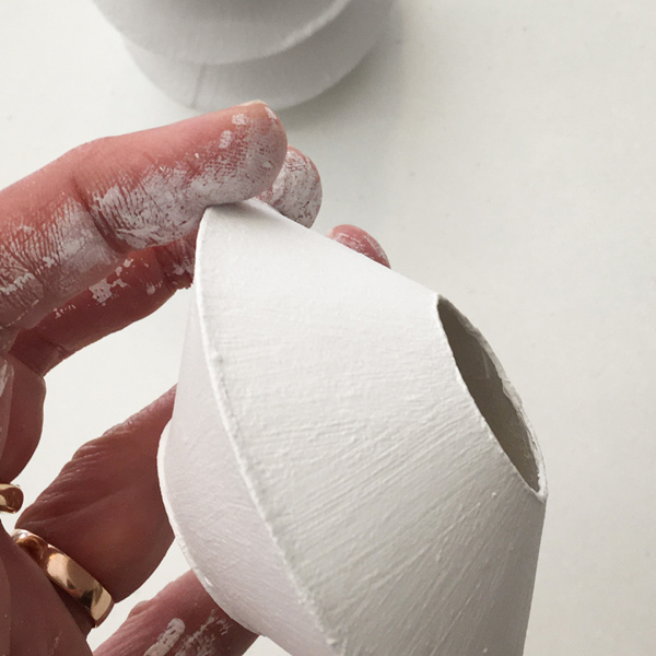 Application de gesso sur un vase en carton en cours de construction